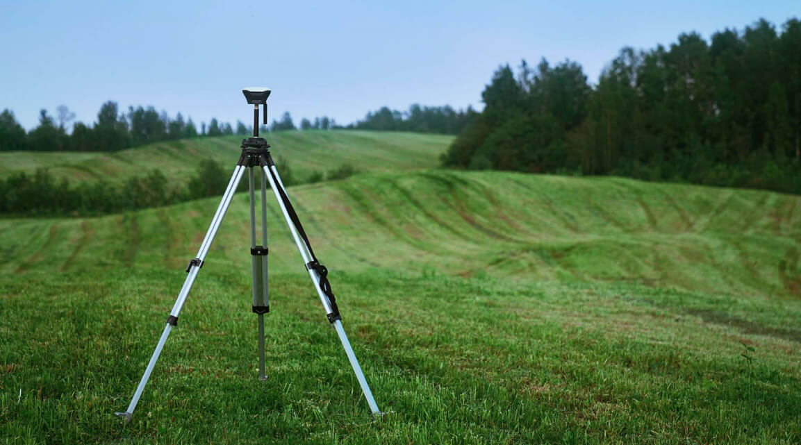 Measuring equipment on a tripod on grassy hills